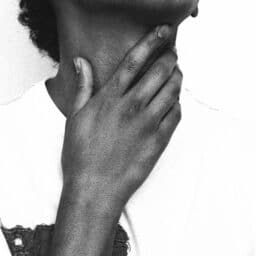 Person rubbing their sore throat