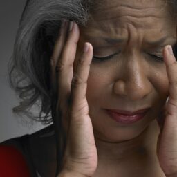 woman holding her head in pain