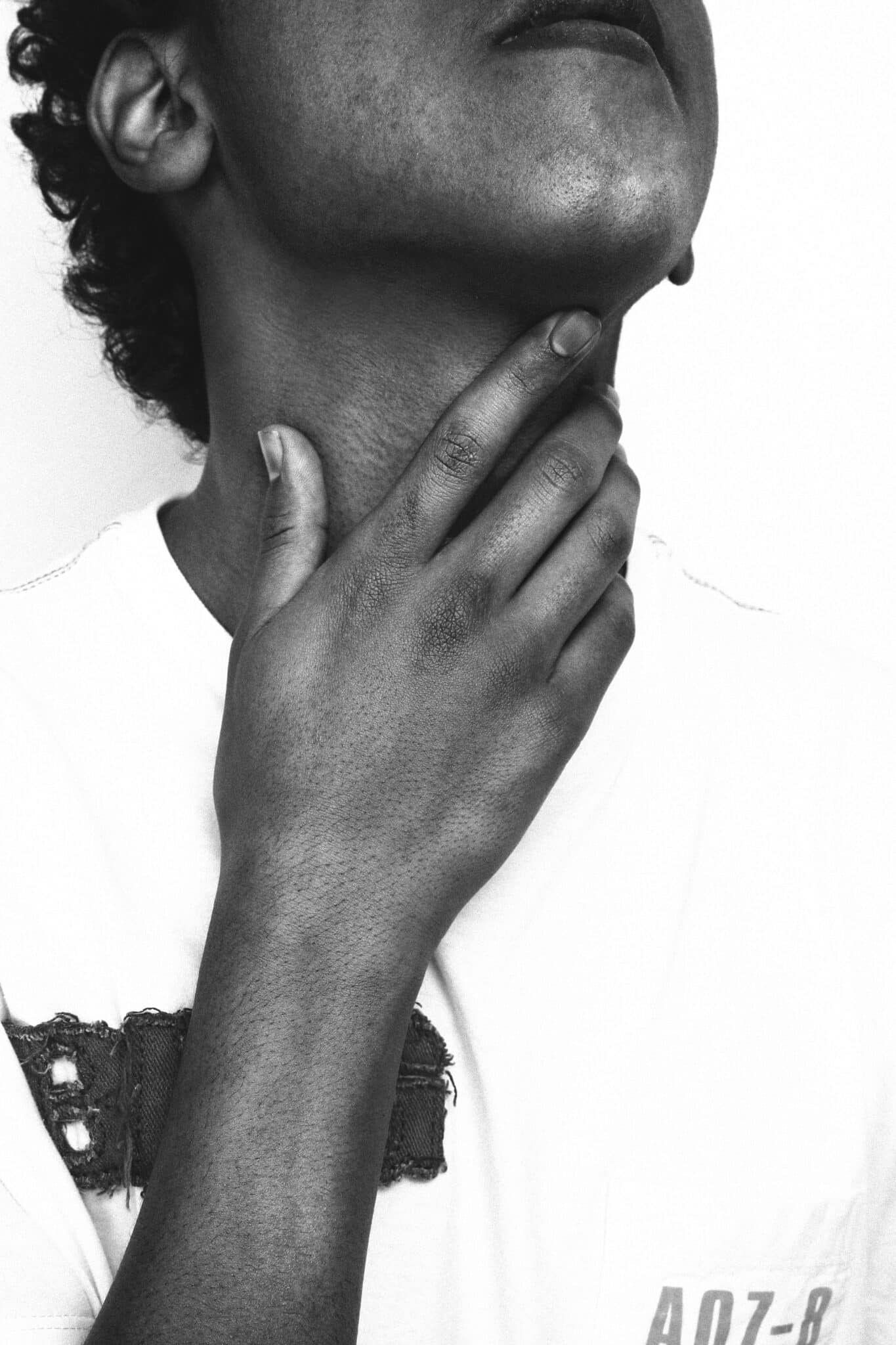 woman rubbing her sore throat 