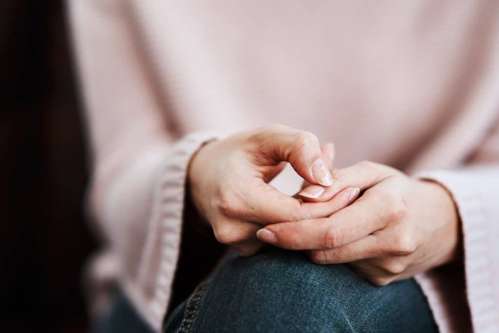 Woman sitting on a sofa and feeling anxious.