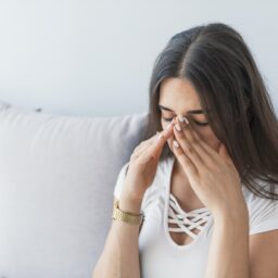 Woman experiencing sinus pressure.