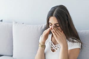 Woman experiencing sinus pressure.