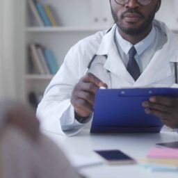 Doctor with clipboard checks up with patient