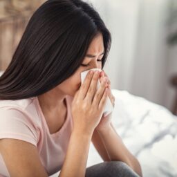 Young woman sick at home with a sinus infection.