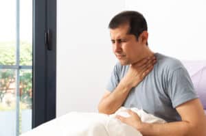 Man waking up with a sore throat.