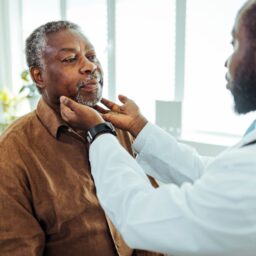 ENT doctor examining a man's throat.