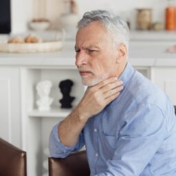 Senior man having trouble swallowing.