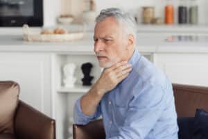 Senior man having trouble swallowing.